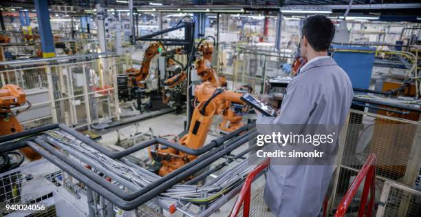 factory engineer using digital tablet - human robot arm stock pictures, royalty-free photos & images