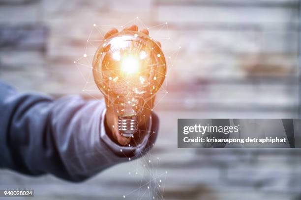 business man holding light bulbs, ideas of new ideas with innovative technology and creativity - energy solutions stock pictures, royalty-free photos & images