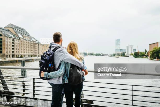 tourist couple taking in river view - berlin tourist stock pictures, royalty-free photos & images