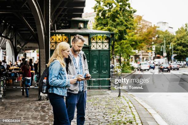 tourist couple finding their bearings in new city - berlin map stock pictures, royalty-free photos & images