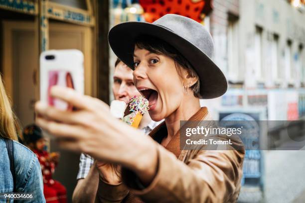 tourist taking selfie while easting an ice cream - fashion food stock pictures, royalty-free photos & images