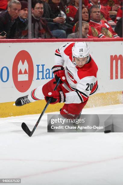 Sebastian Aho of the Carolina Hurricanes falls toward the puck in the first period against the Chicago Blackhawks at the United Center on March 8,...