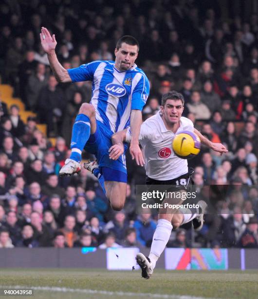 Aaron Hughes of Fulham and Paul Scharner of Wigan Athletic in action during the Barclays Premier League match between Fulham and Wigan Athletic held...