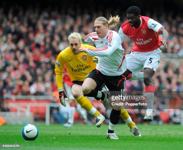Andriy Voronin of Liverpool goes past Kolo Toure and Arsenal goalkeeper Manuel Almunia but fails to score during the Barclays Premier League match...