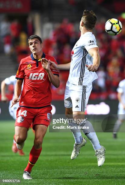 Dylan Fox of Wellington Phoenix heads the ball back over George Blackwood of Adelaide United during the round 25 A-League match between Adelaide...