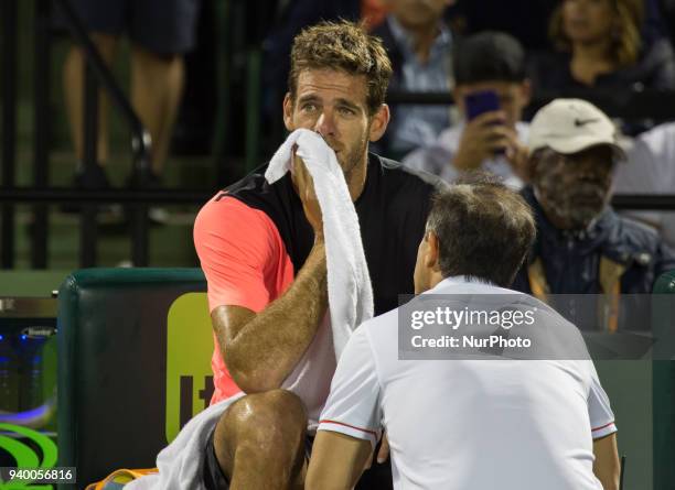 Juan Martin Del Potro, from Argentina, talking with a physiotherapist after feeling some pain during his quarter final match at the Miami Open. Del...