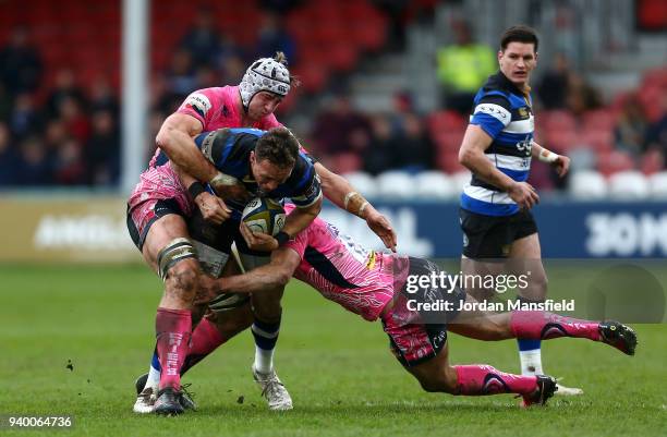 James Wilson of Bath is tackled by Toby Salmon of Exeter Chiefs and Ollie Devoto of Exeter Chiefs during the Anglo-Welsh Cup Final between Bath Rugby...