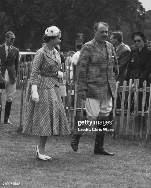 Queen Elizabeth II walks to the Royal Enclosure during the Coronation Cup match between England and Argentina at Cowdray Park, UK, accompanied by...