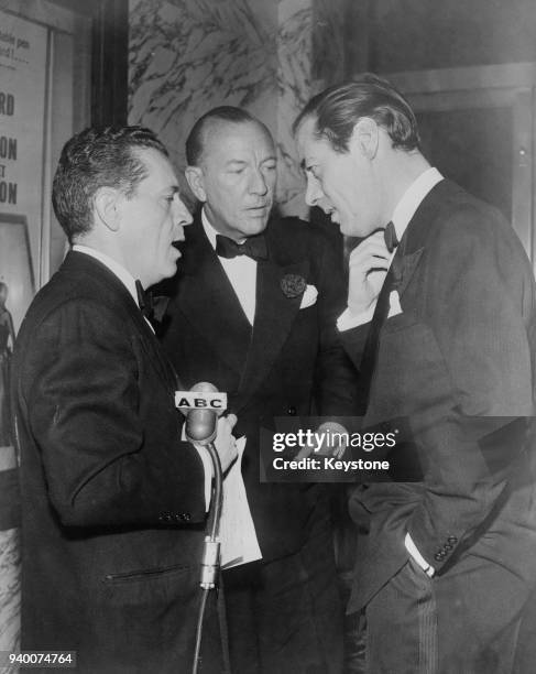 Actors Noël Coward and Rex Harrison being interviewed by an ABC reporter at the opening of Coward's play 'The Astonished Heart' at the Park Avenue...
