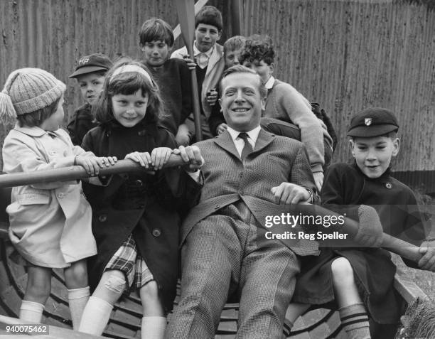 Geoffrey Johnson-Smith , the Conservative MP for East Grinstead, rowing a group of children in a fishing boat in his constituency during Christian...