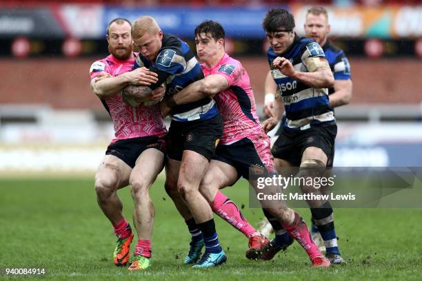 Tom Homer of Bath is tackled by Tom Hendrickson of Exeter Chiefs and James Short of Exeter Chiefs during the Anglo-Welsh Cup Final between Bath Rugby...