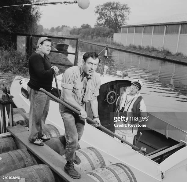 From left to right, comedians Ronnie Barker , Harry H. Corbett and Eric Sykes film a scene for 'The Bargee' on a UK canal, 16th October 1963.
