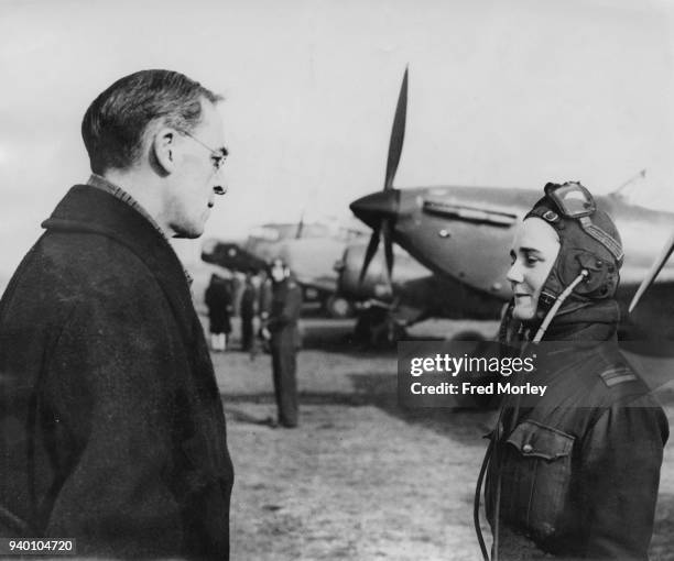 Sir Stafford Cripps , the Minister of Aircraft Production, talks to Flight Captain Joan Hughes , a ferry pilot at an ATA Depot in England, during...