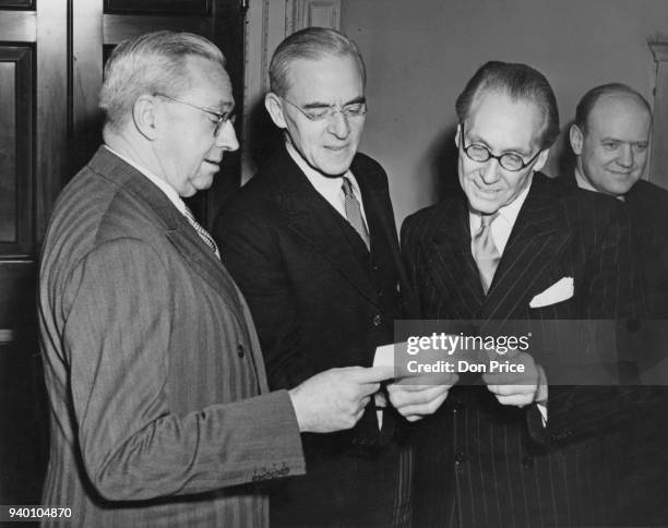 Sir Stafford Cripps receives a cheque for £8 000 from Norman Mighell , Acting High Commissioner for Australia, at the Treasury in London, 16th...