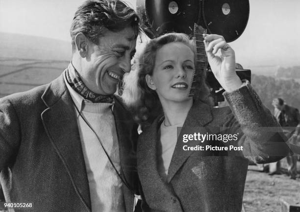 Irish actress Peggy Cummins examines a length of film stock with cinematographer Freddie Young , during the filming of 20th Century Fox's 'Escape' in...