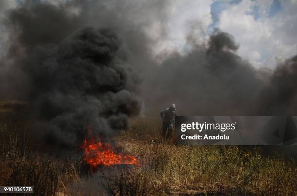 Demonstrators burn tyres in response to Israeli forces' intervention during the demonstration under the name of the "Great Return March" at Israeli...