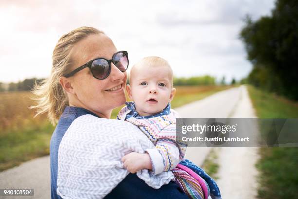 baby looks over mother's shoulder while outside on a walk - amboise stock pictures, royalty-free photos & images