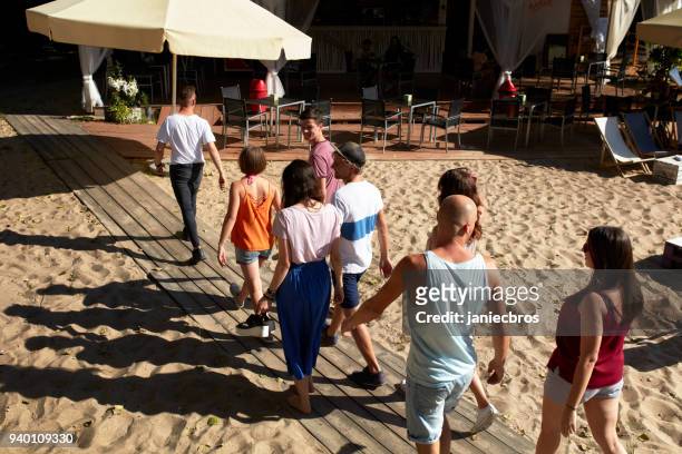 group of friends meeting on an urban beach - beach club stock pictures, royalty-free photos & images