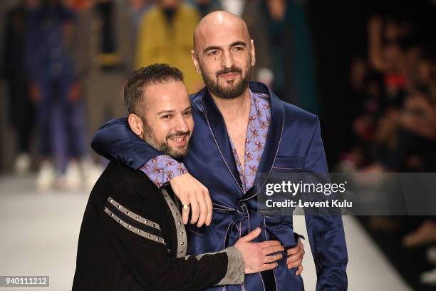 Fashion designer Emre Erdemoglu and singer Soner Sarikabadayi walk the runway at the Emre Erdemoglu show during Mercedes Benz Fashion Week Istanbul...