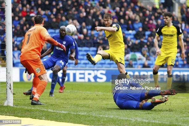 Junior Hoilett of Cardiff City watches as his shot is cleared by Kyle McFadzean of Burton Albion during the Sky Bet Championship match between...