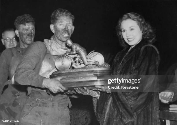 English actress Hazel Court presents the Daily Mail National Speedway Trophy to Jack Parker , captain of the winning Belle Vue team from Manchester,...