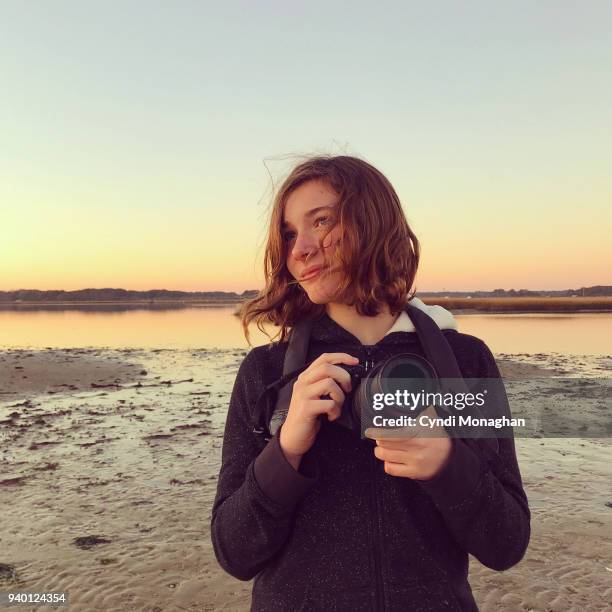 girl with camera at sunset - us girls on the beach stock-fotos und bilder