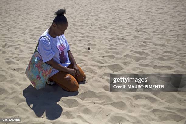 Paloma Maria Novaes mother of Benjamin, 1 year old, shot dead during a police operation at Complexo do Alemao favela, on March 16, prays during a...