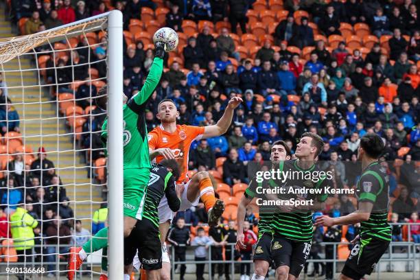 Doncaster Rovers' Marko Marosi punches clear under pressure from Blackpool's Will Aimson during the Sky Bet League One match between Blackpool and...