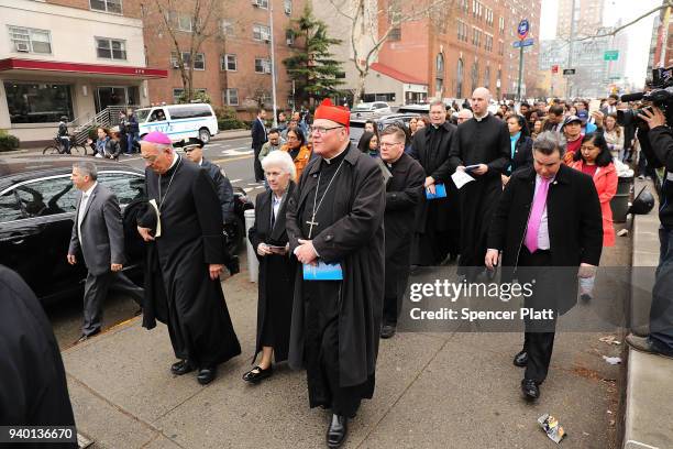 Cardinal Timothy Dolan, archbishop of New York City, joins worshippers as they walk to a station during the Way of the Cross procession over the...