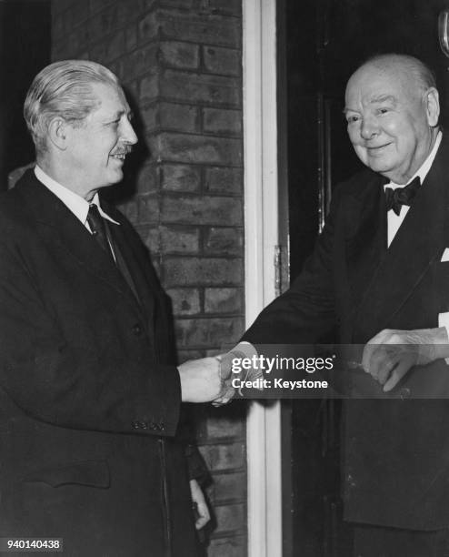 British Conservative statesman Winston Churchill shakes hands with Harold Macmillan, the new Prime Minister, as the latter arrives at 28 Hyde Park...