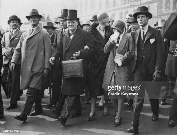 British Conservative politician Winston Churchill , Chancellor of the Exchequer, makes his way to the House of Commons in London to present his...