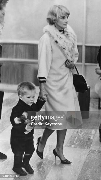 Australian actress Diane Cilento arrives at London Airport with her son Jason Connery, 13th April 1965. They are flying to the Bahamas to visit...