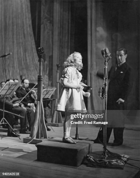 Year-old British actress and singer Petula Clark performs at the BBC's Empire birthday party, watched by bandleader Geraldo , December 1942.