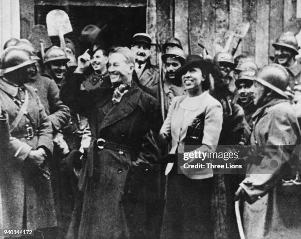 Entertainers Maurice Chevalier and Josephine Baker are cheered by officers and men of the French Army as they arrive at the front during World War...