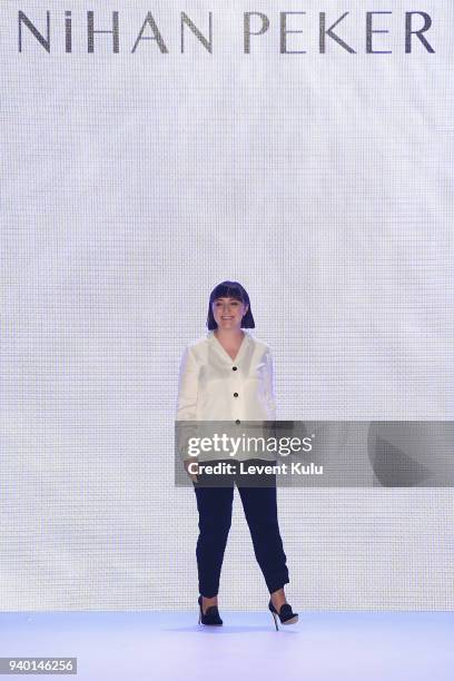 Designer Nihan Peker acknowledges the applause of the audience after her show during Mercedes Benz Fashion Week Istanbul at Zorlu Performance Hall on...