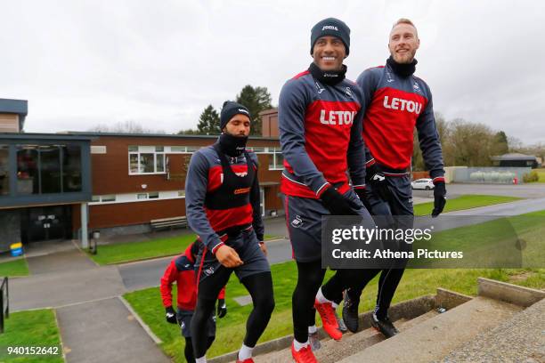 Kyle Bartley, Luciano Narsingh and Mike van der Hoorn lead team mates to the pitch during the Swansea City Training Session and Press Conference at...