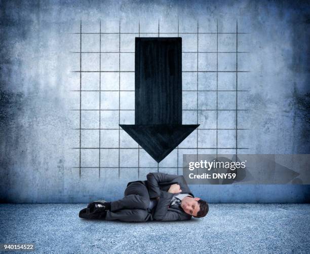 businessman curled up in fetal position distraught over falling results - hugging knees stock pictures, royalty-free photos & images