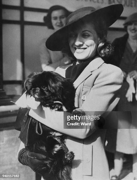 Actress Diana Churchill after her wedding to actor Barry K. Barnes at Caxton Hall in London, 21st March 1938. She is holding a dog which was...