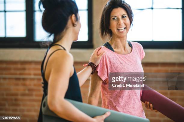 twee vrouwen praten en lachen. yoga opleiding lesvoorbereiding - two women talking stockfoto's en -beelden