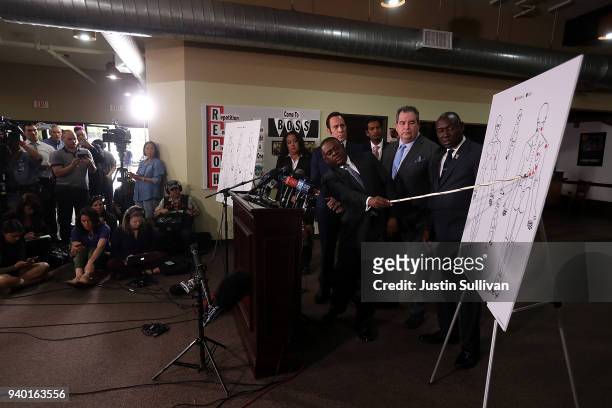 Dr. Bennet Omalu, attorney Dale Galipo, attorney Brian Panish and attorney Ben Crump examine a picture showing gunshot wounds to Stephon Clark during...