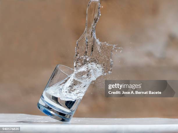 impact of a glass of crystal with water that falls down on the soil. - crystal glasses stockfoto's en -beelden