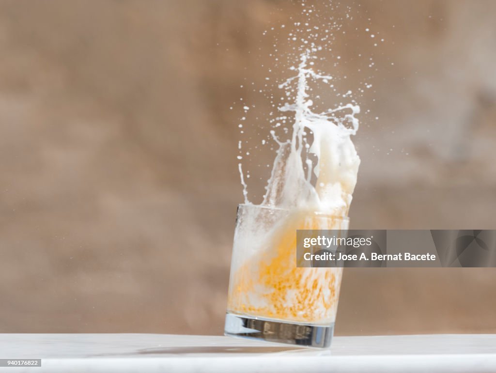 Impact of a glass with beer that falls down on the soil.