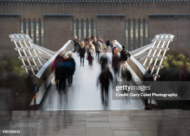 long exposure of walkers on millennium bridge, london - cruzar puente fotografías e imágenes de stock