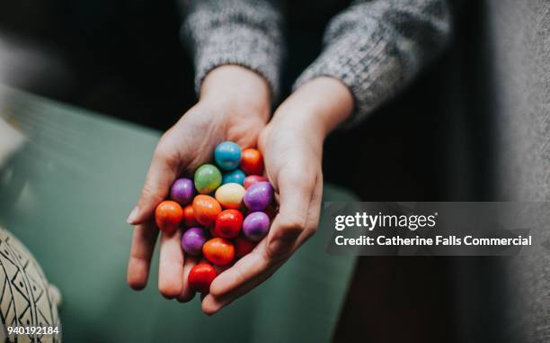 childs hands holding mini eggs - chocolate egg stock pictures, royalty-free photos & images