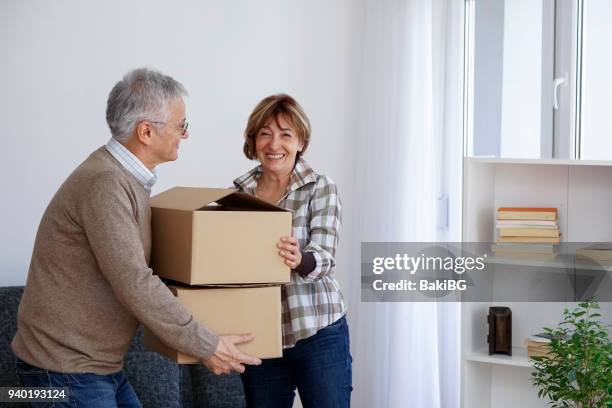 senior couple moving into a new apartment - senior moving house stock pictures, royalty-free photos & images