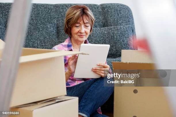 senior woman moving into a new apartment - letting it all hang out stock pictures, royalty-free photos & images