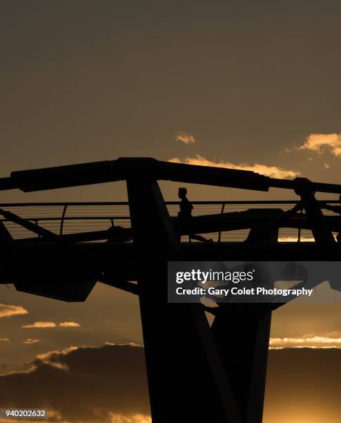 runner silhouetted on millennium bridge - gary colet stock pictures, royalty-free photos & images