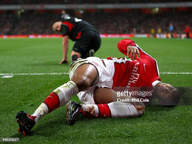 Armand Traore of Arsenal holds his shin after a tackle by Andy Wilkinson of Stoke City during the Barclays Premier League match between Arsenal and...