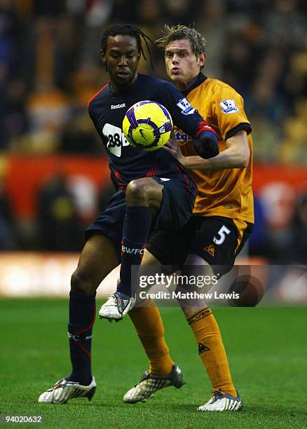 Jlloyd Samuel of Bolton and Richard Stearman of Wolverhampton challenge for the ball during the Barclays Premier League match between Wolverhampton...