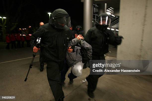Riot police arrest a person after the Bundesliga match between VfB Stuttgart and VfL Bochum at Mercedes-Benz Arena on December 5, 2009 in Stuttgart,...